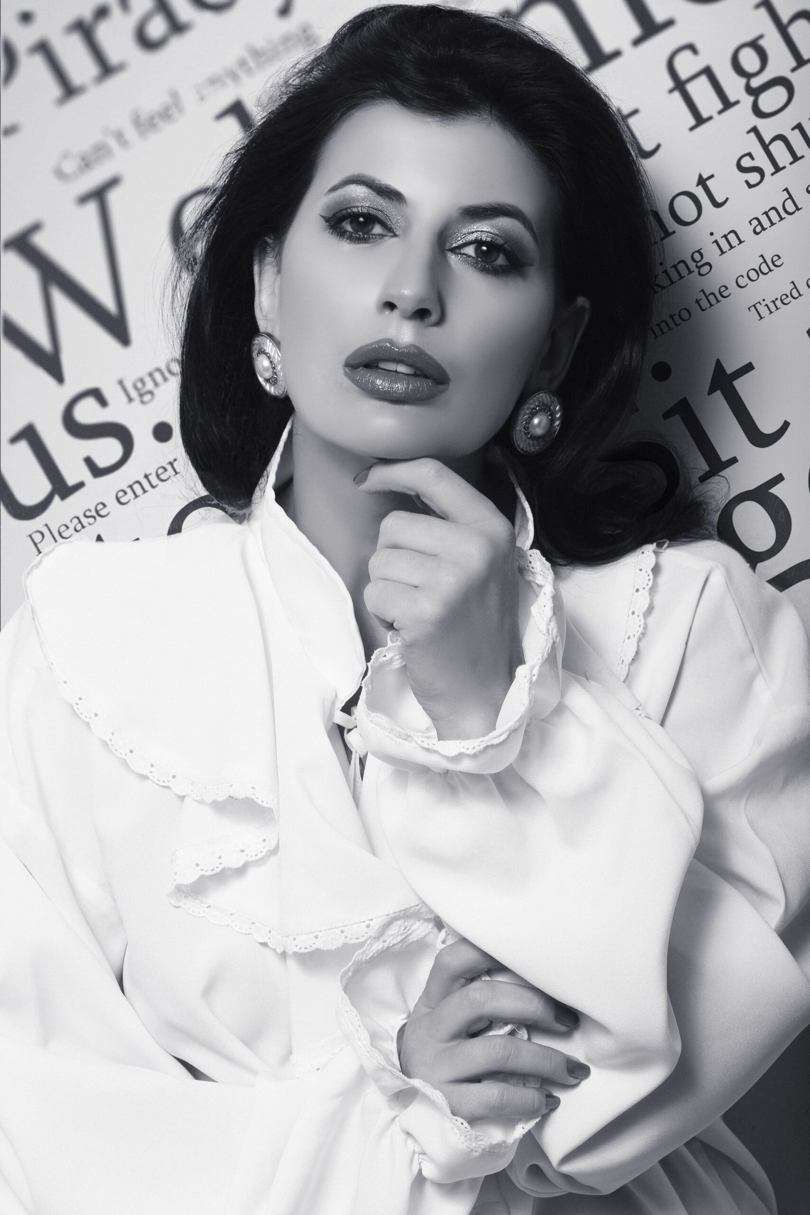 Elegant black and white portrait of a woman in vintage attire with bold accessories.